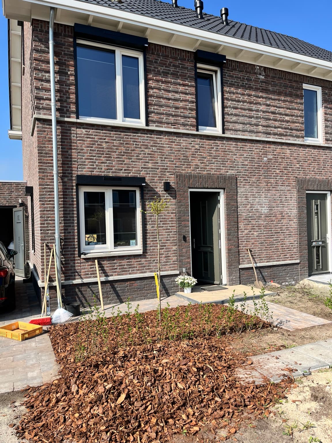 Front of a new-build home fitted with black exterior roller shutters.