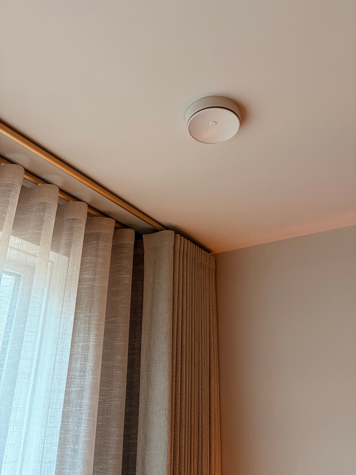 Ceiling ventilation outlet painted to blend with the surrounding warm neutral ceiling.