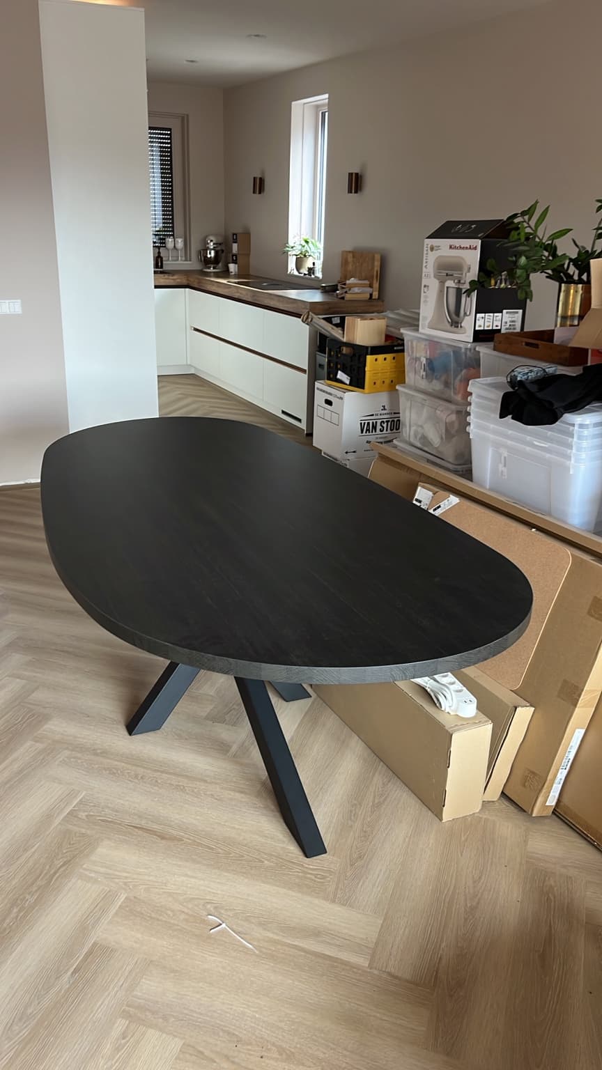 Round dining table in a new home while boxes and finishing work remain.