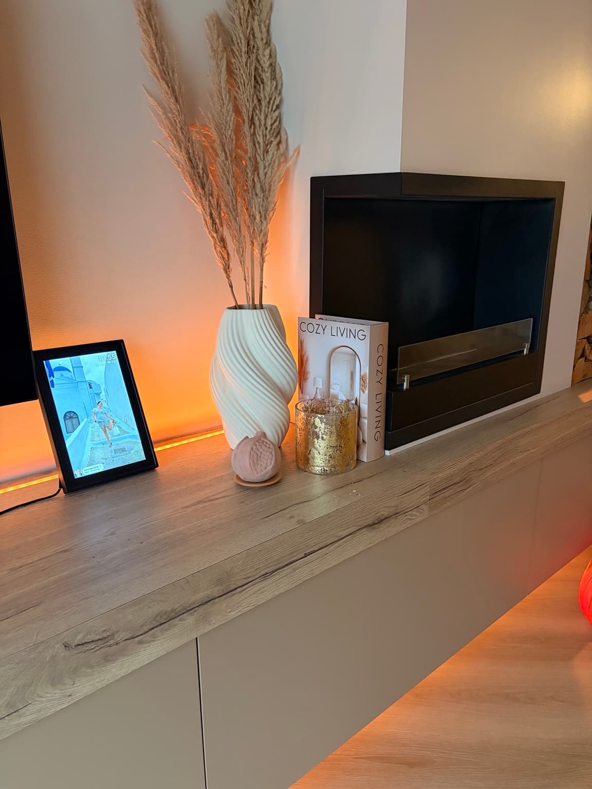 Melograno home fragrance styled beside a vase and fireplace in a warmly lit living room.