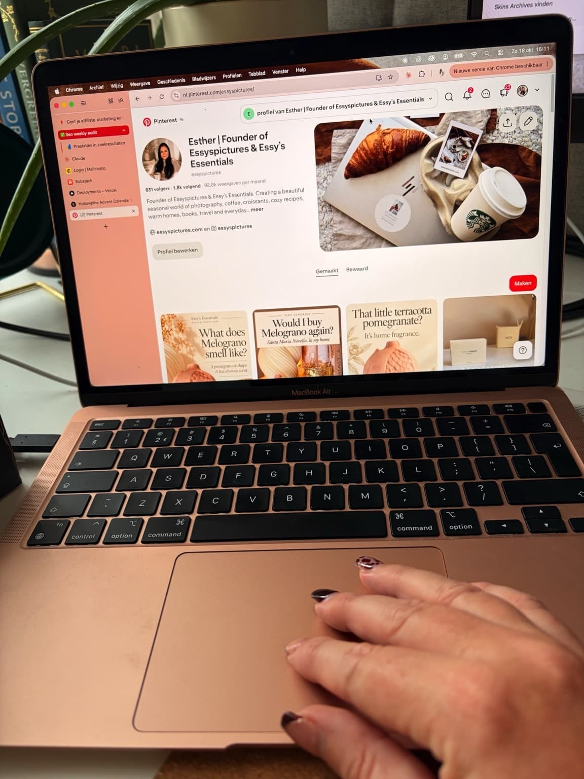 Esther’s hand on her laptop, with her own Pinterest profile open on screen.