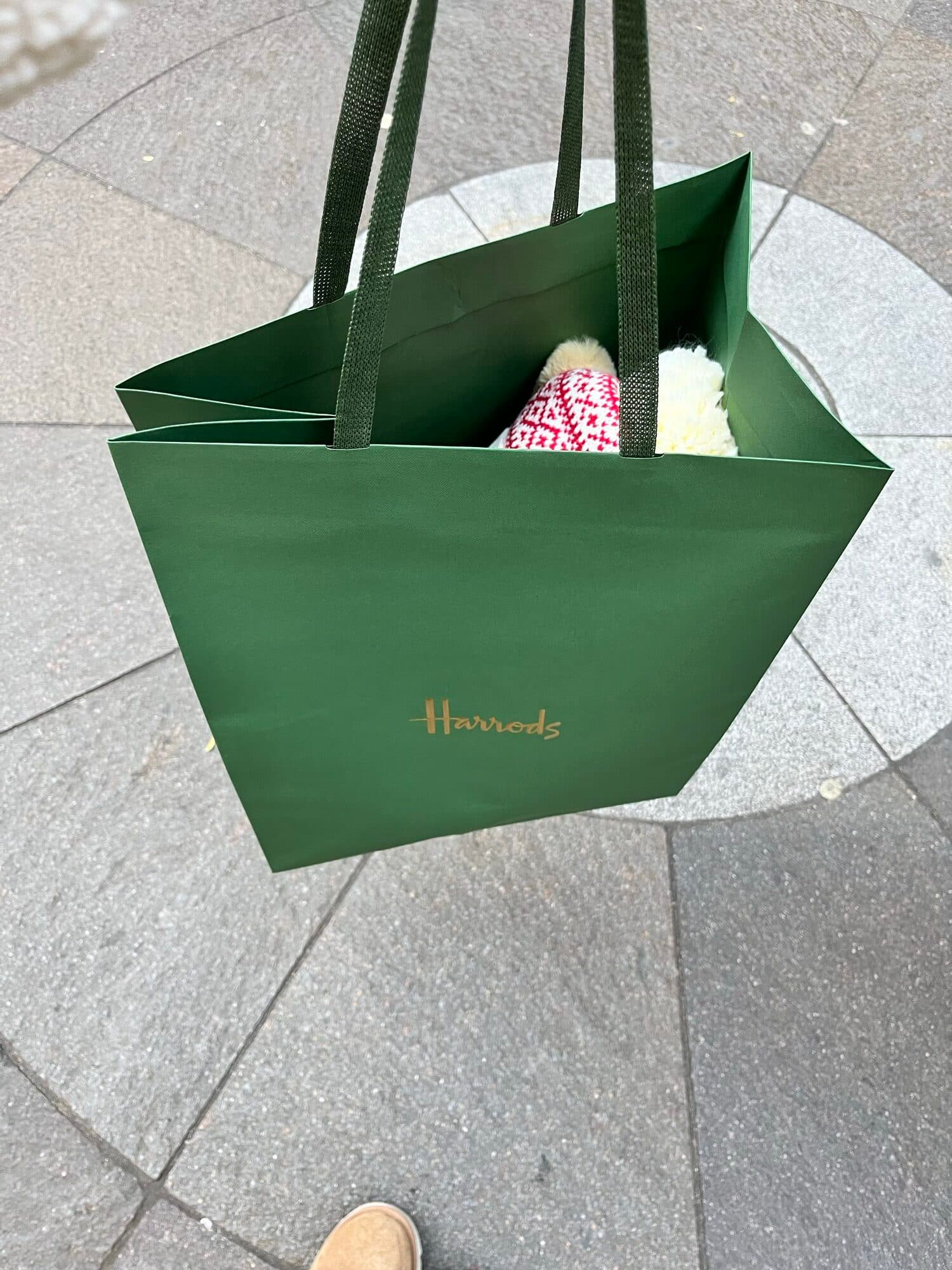 Harrods shopping bag with a wrapped Christmas ornament inside