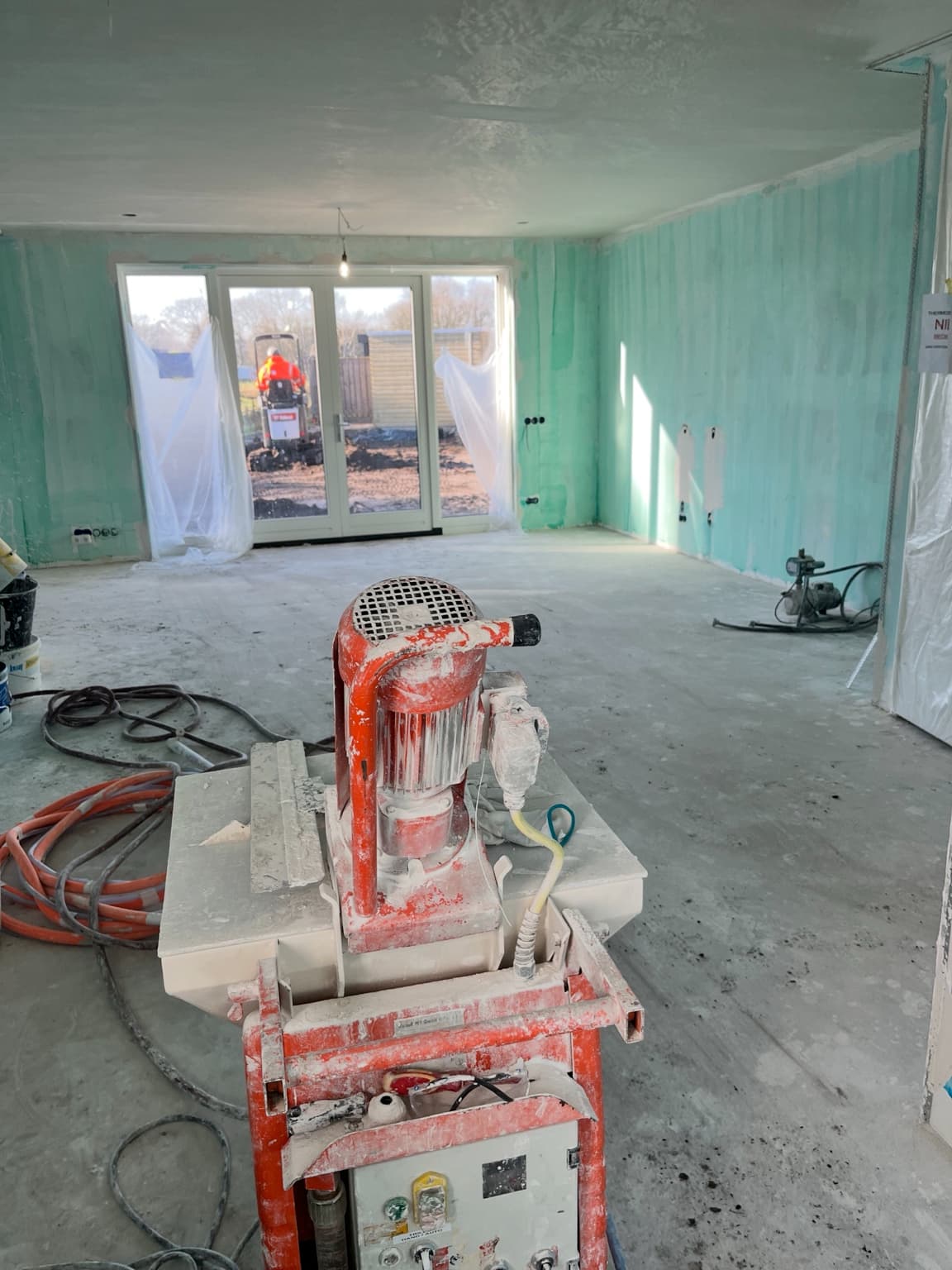 New-build interior during plastering and wall preparation.
