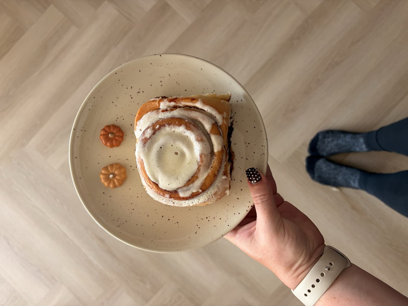 A Cinnabon cinnamon roll thick with icing, fresh from the shop.