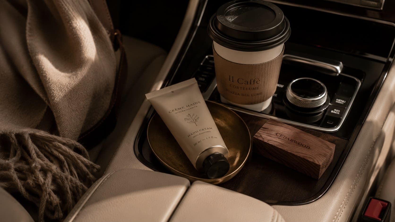 Hand cream, coffee and a cedar detail in the console of a safely parked car.
