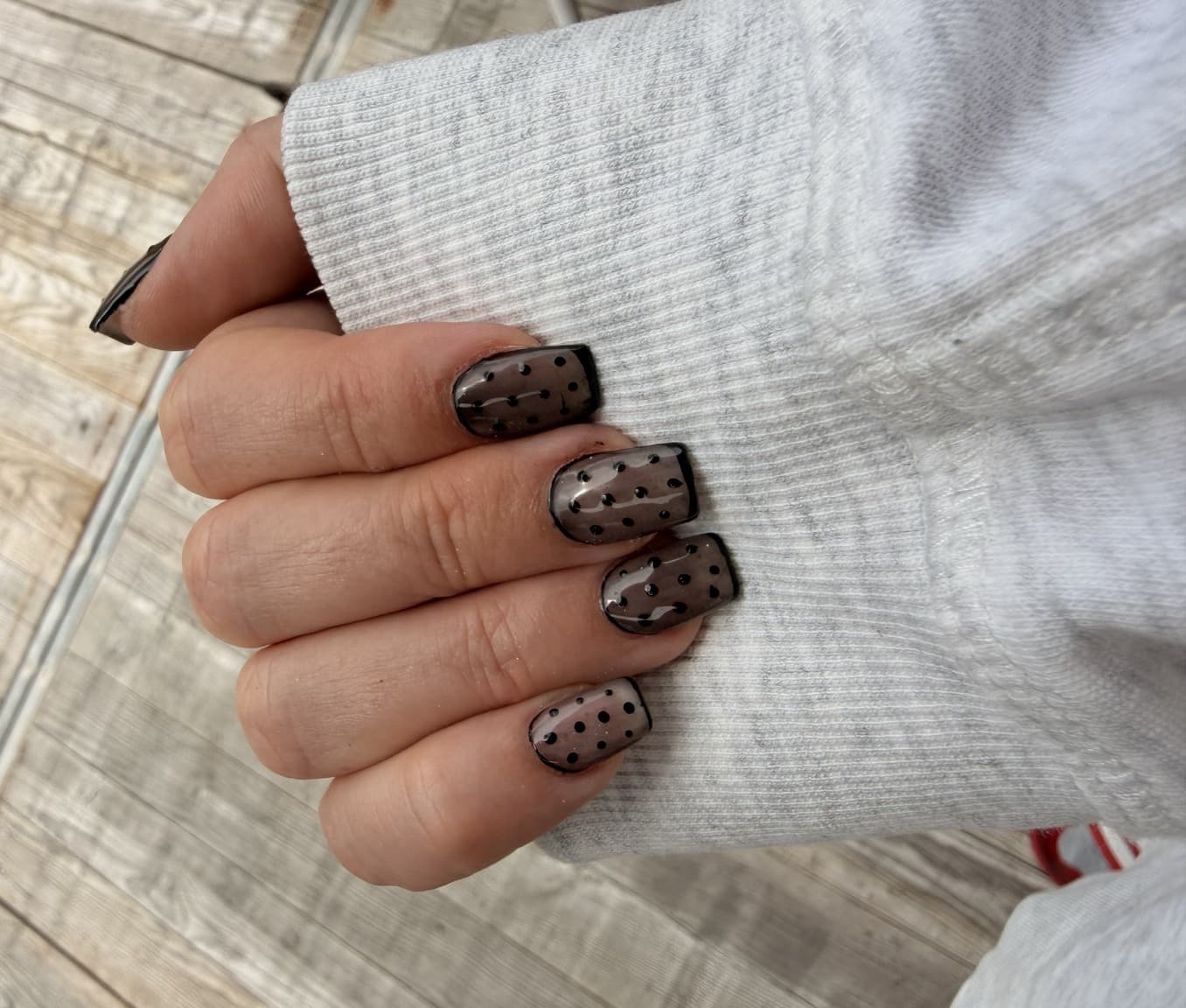 Smoky sheer taupe nails with black polka dots and a fine black outline for late summer and early autumn