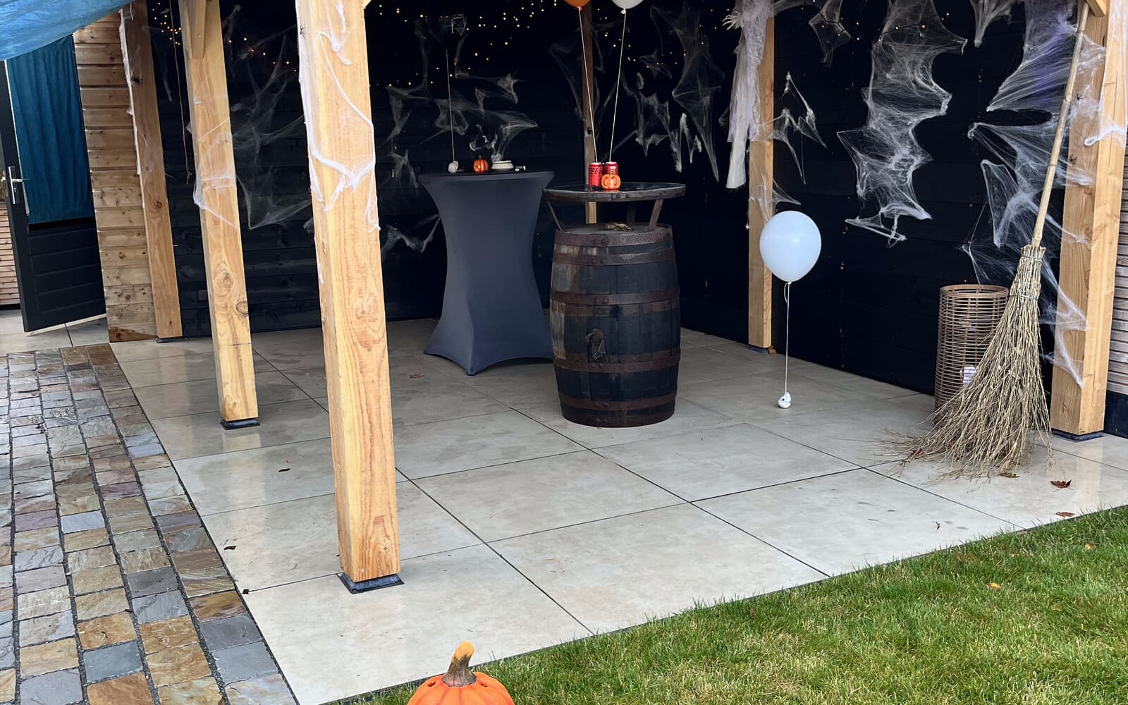 The covered garden pergola at Amberfell, dressed with cobwebs, string lights and a broom for the Halloween party.