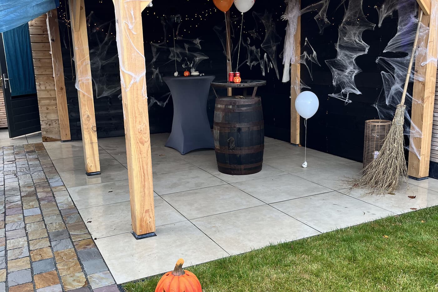 The garden pergola and bar area, dressed for Halloween with cobwebs and string lights.