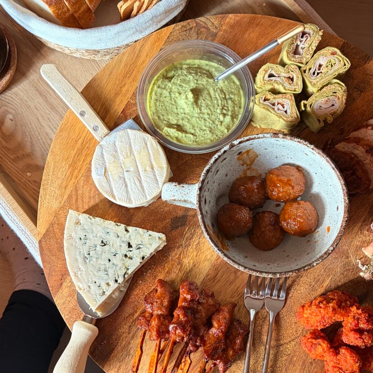 A large wooden board of picky bits - bread, cheese, dips, wraps and skewers - set out for the evening.