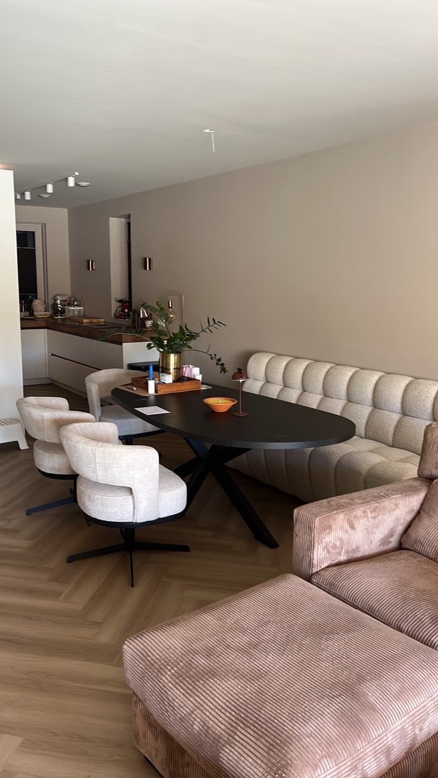 Finished open-plan dining and living area with table, chairs and soft furnishings.