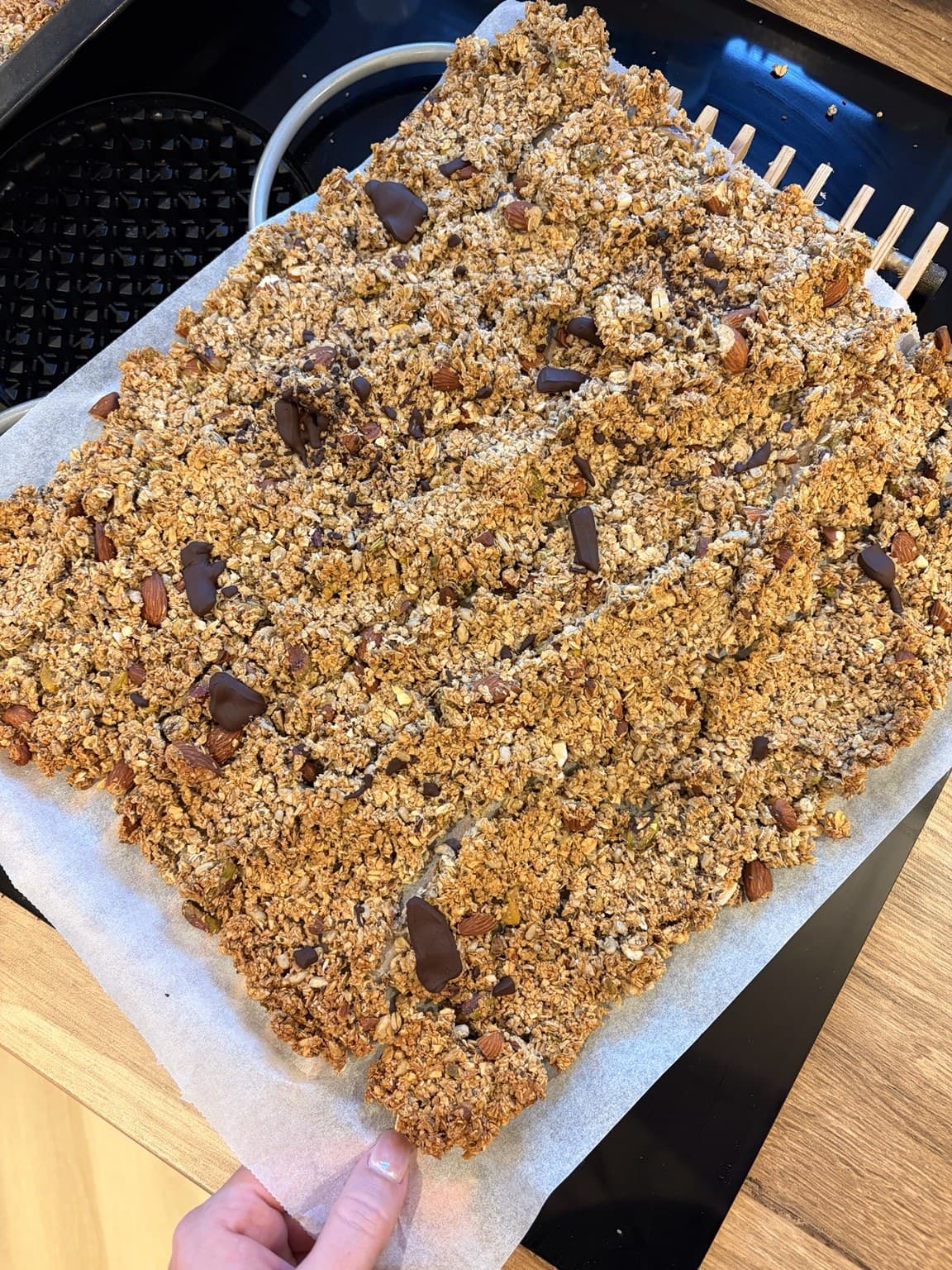 A tray of freshly baked granola, golden and clustered, just out of the oven