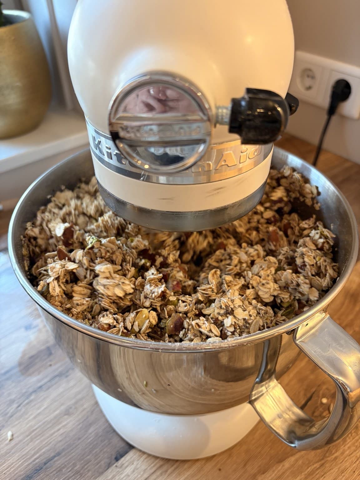 A mixing bowl of granola ingredients being stirred before baking
