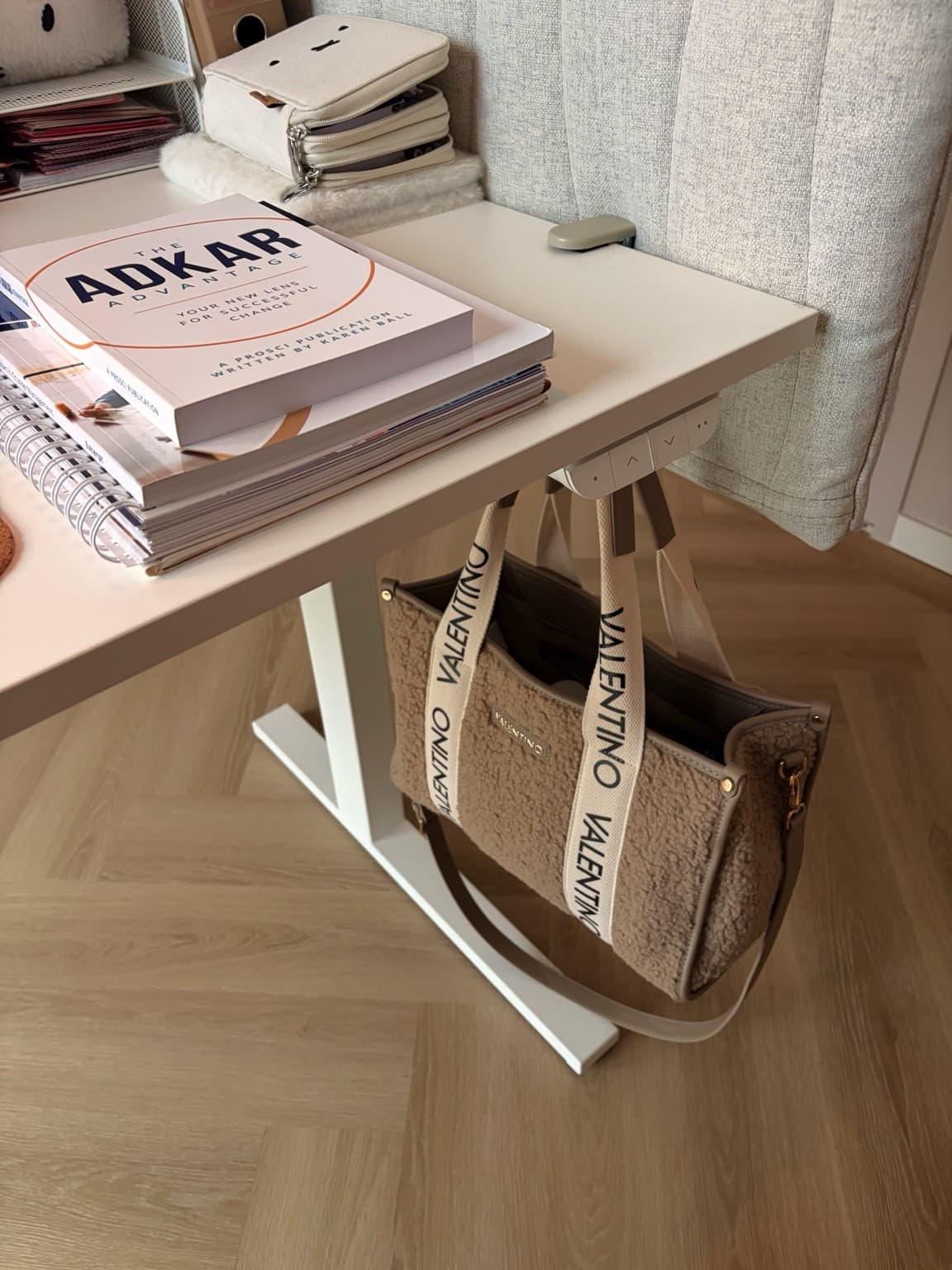 Books, Miffy stationery cases and the height controls on Esther’s white desk.