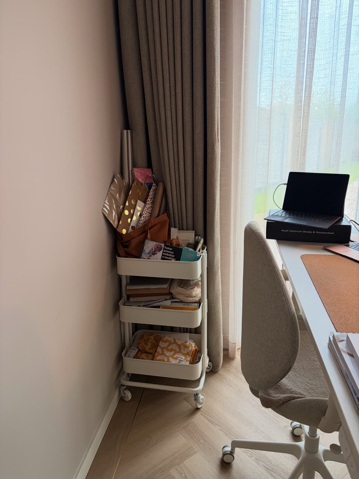 A white trolley beside Esther’s desk holds wrapping paper, notebooks and other supplies.