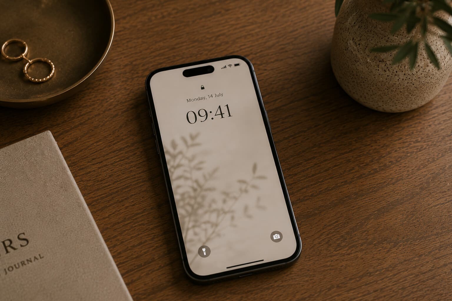 A phone with a quiet, notification-free lock screen resting on a table.