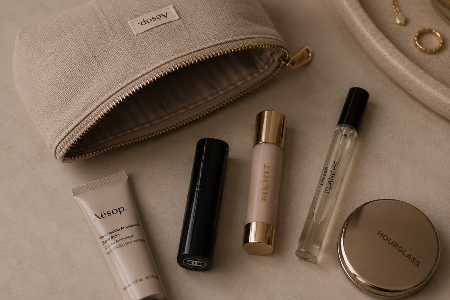 A small compact pouch with a few essential touch-up beauty items laid out beside it.
