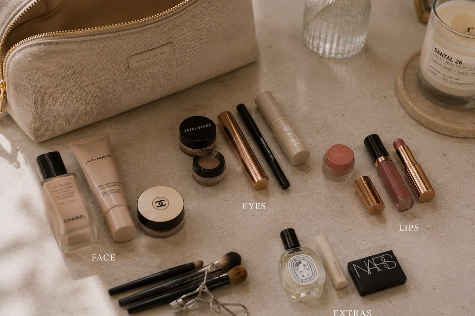 A makeup bag emptied and sorted into small groups on a clean surface.