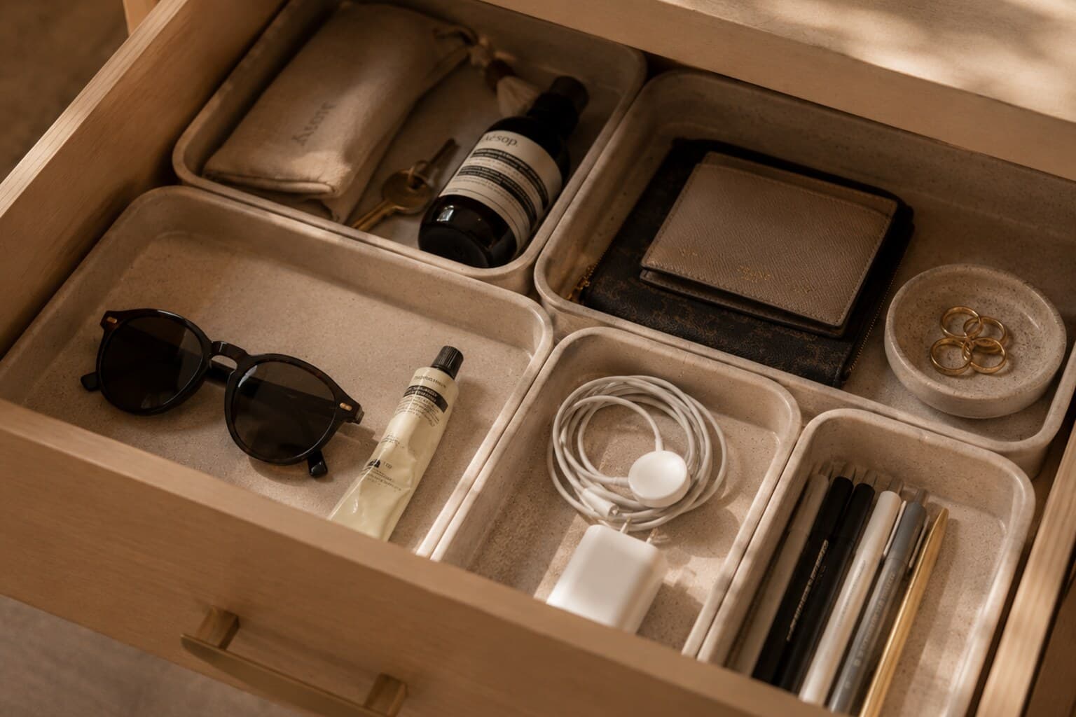A single organised drawer with items grouped into shallow trays, photographed mid-edit.