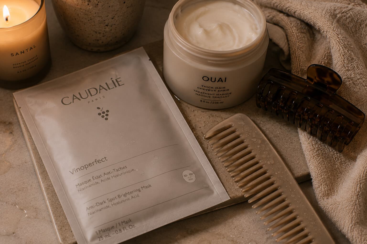 A hydrating face mask and hair treatment laid out for a post-travel recovery routine.