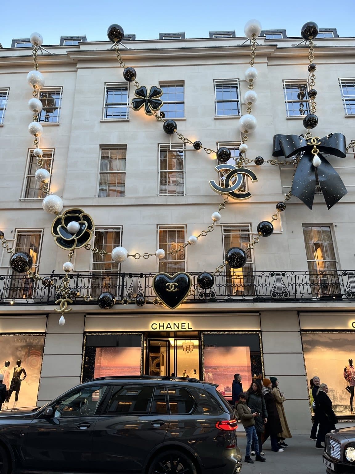 The Chanel boutique on Bond Street with black and white baubles, camellias, garlands and a large black bow across the façade.