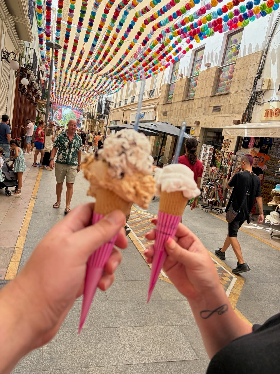 Ice creams under colourful overhead street decorations in Ronda