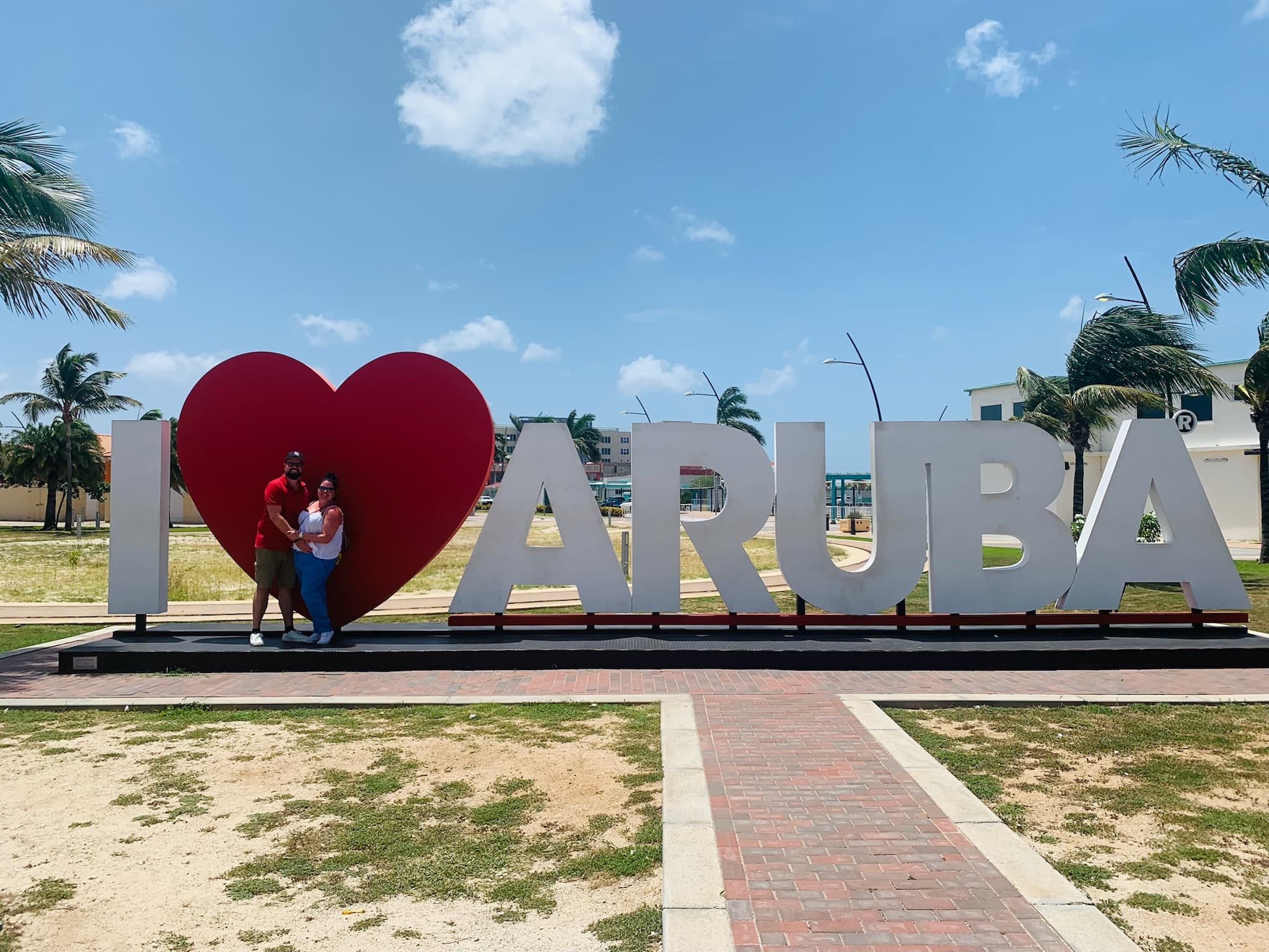 Esther and Bas standing at the I Love Aruba sign in Oranjestad
