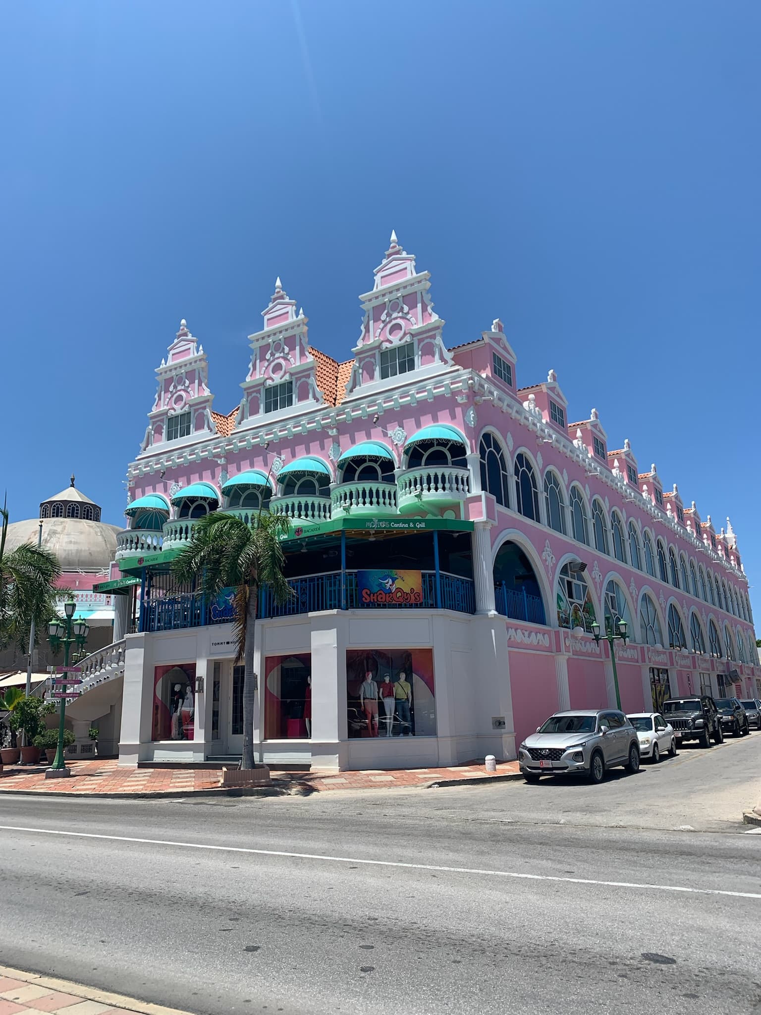 Pink Royal Plaza building under a clear blue sky in Oranjestad