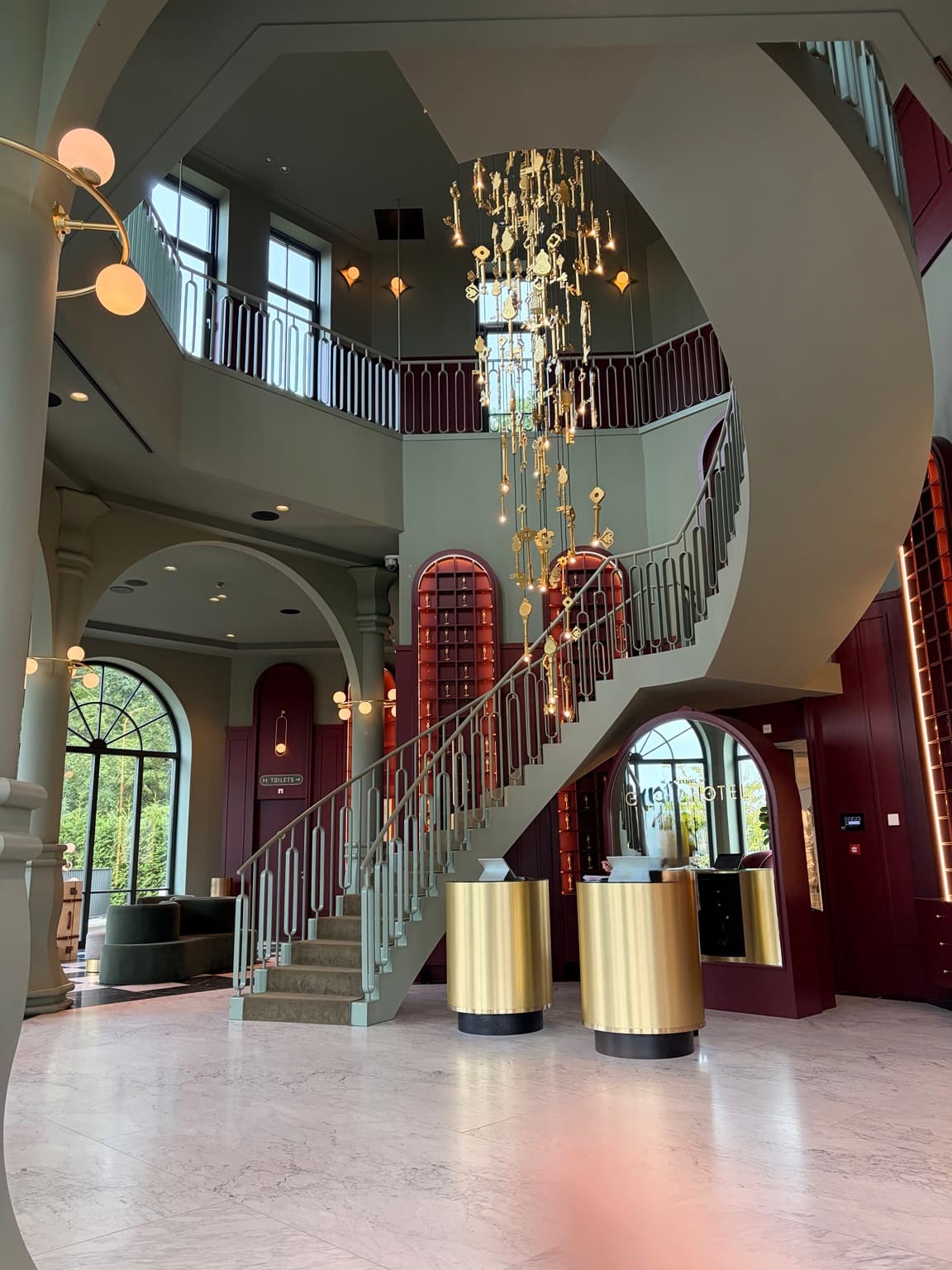 Staircase, golden reception desks and a chandelier of hanging keys in the Efteling Grand Hotel foyer